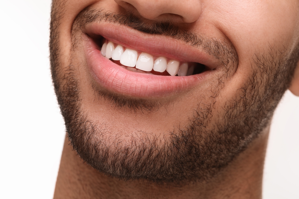 Smiling,man,with,healthy,clean,teeth,on,white,background,,closeup